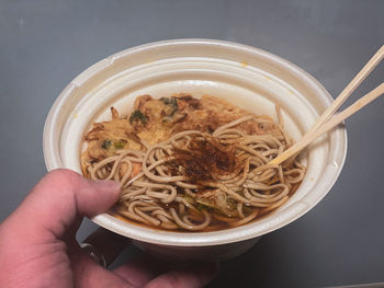 Midsection of person holding noodles in bowl