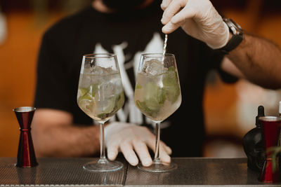 Midsection of woman holding wine glass on table