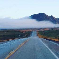 Road passing through landscape against sky