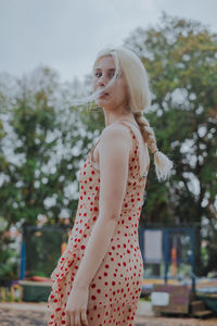 Portrait of beautiful woman with braided hair standing outdoors