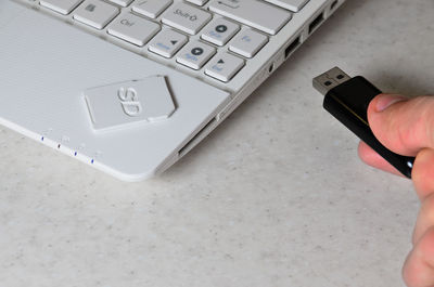 Cropped hand inserting usb stick to laptop