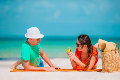 Rear view of people sitting on beach