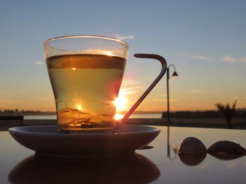 Close-up of tea served on table during sunset