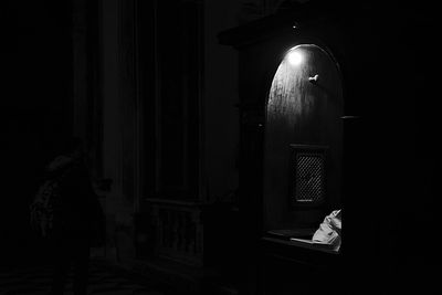 Rear view of man in illuminated building