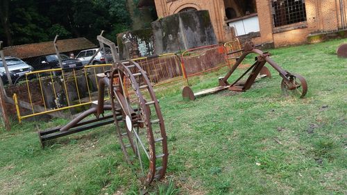 Old metal structure amidst plants on field