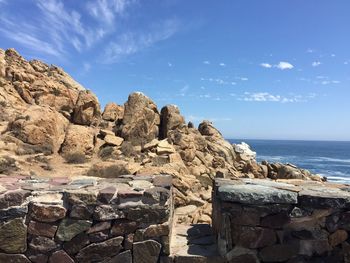 Scenic view of rocks on beach against sky