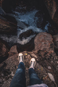 Low section of man standing on rock