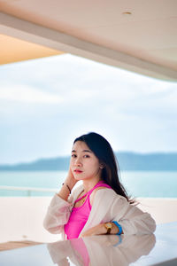 Portrait of young woman standing at beach