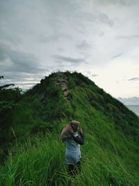 Woman standing on mountain against sky