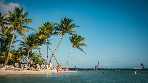 People on beach against blue sky