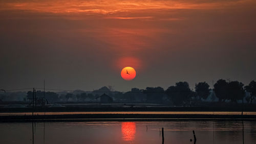 Scenic view of lake against orange sky