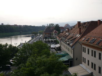 High angle view of buildings by river against sky