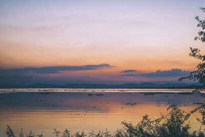 Long exposure vanilla colorful sky and lake reflection with mountains in the background.