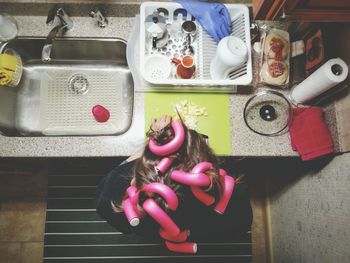 Close-up of multi colored objects on table and woman head and hair