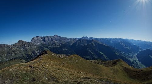 Scenic view of mountains against clear blue sky