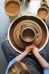 Overhead view of woman working on pottery wheel