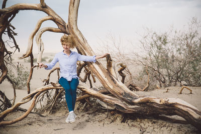 Woman on dead tree