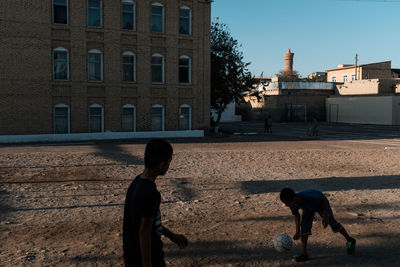 People playing in city against buildings