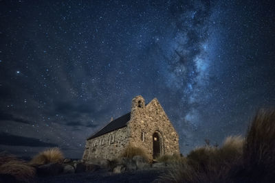 Low angle view of church against star field