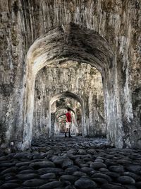 Rear view of woman standing at old historical building