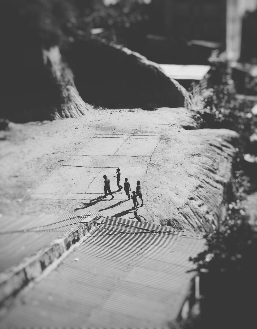 men, lifestyles, walking, leisure activity, shadow, high angle view, person, togetherness, sunlight, the way forward, selective focus, street, bicycle, medium group of people, day, full length, outdoors, transportation