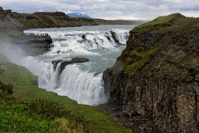 Scenic view of waterfall against sky