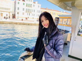 Portrait of smiling young woman standing on boat