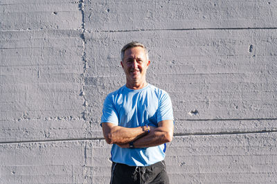 Portrait of man standing against wall