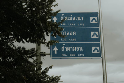 Low angle view of road sign against sky