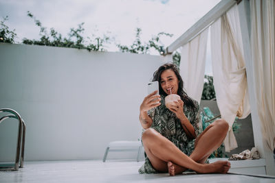 Portrait of smiling young woman sitting outdoors