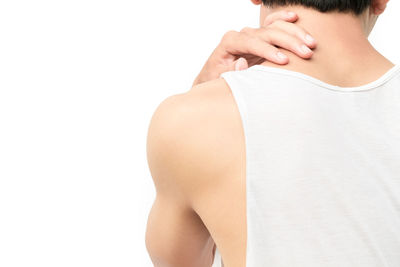 Rear view of man touching hair over white background