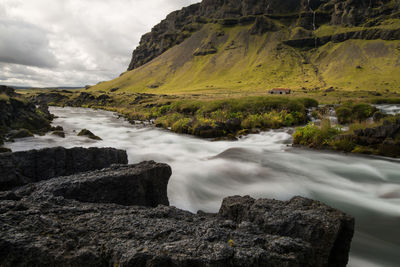 Scenic view of waterfall against sky
