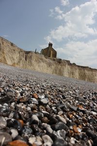 Surface level of stones on beach against sky