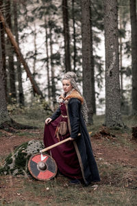 Portrait of young woman standing in forest