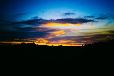 Silhouette of landscape against cloudy sky