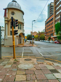 Street by buildings against sky in city