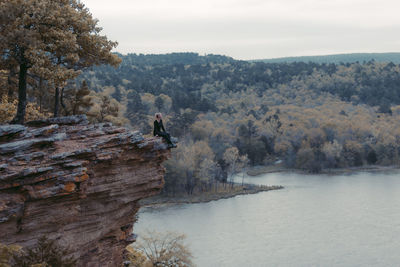 Man amidst trees against sky