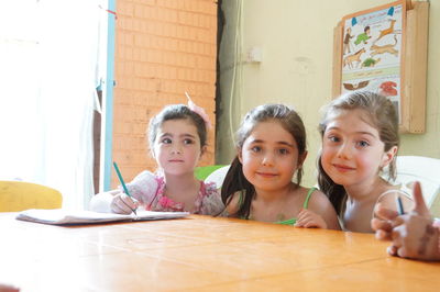 Portrait of siblings sitting on table