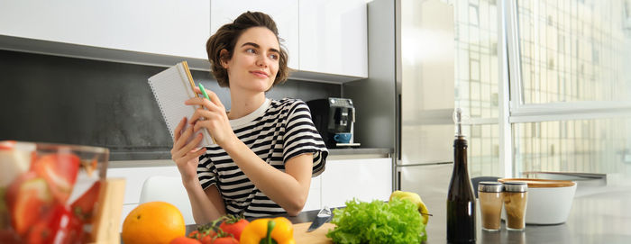 Portrait of young woman using mobile phone at home