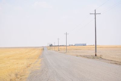 Road amidst field against sky