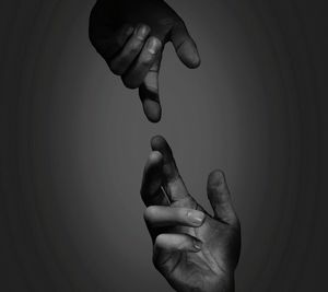 Cropped hands of people against gray background