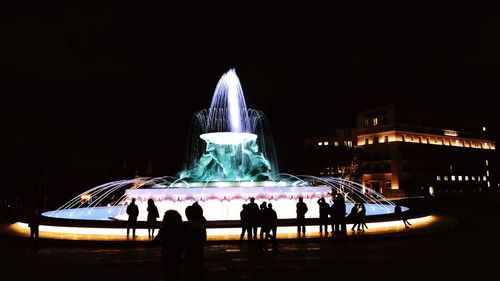 People at music concert against sky at night