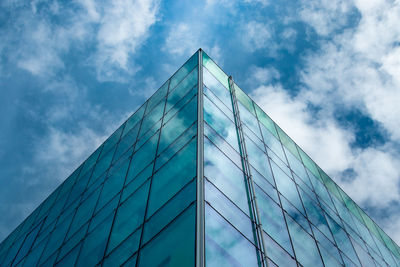 Low angle view of glass building against sky