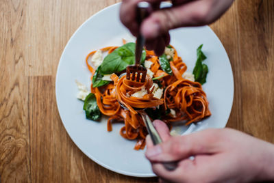 Cropped image of hands having pasta in restaurant