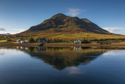 Scenic view of lake and mountains against blue sky