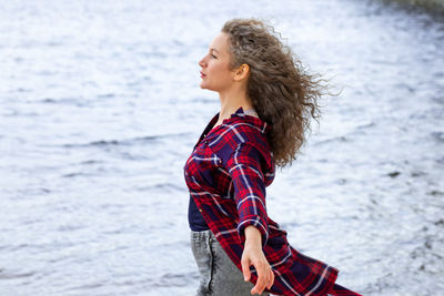 Side view of woman standing at beach