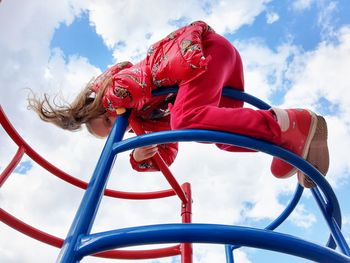 Low angle view of girl in playground against sky