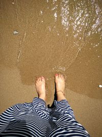 Low section of woman standing on beach