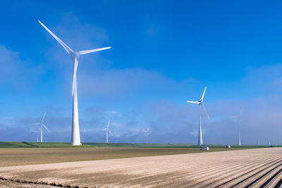 Windmill on field against sky