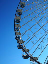 Low angle view of ferris wheel against blue sky